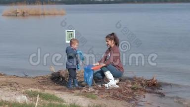 爱护自然生态，小男孩帮助女志愿者积极分子清理污染的河岸塑料垃圾和